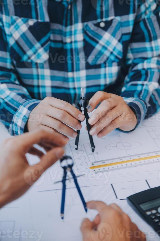 engineer people meeting working and pointing at a drawings in office for discussing. Engineering tools and construction concept. photo