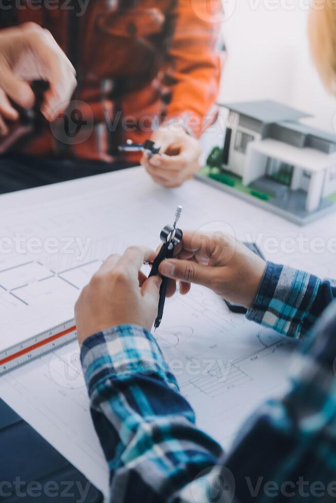 engineer people meeting working and pointing at a drawings in office for discussing. Engineering tools and construction concept. photo