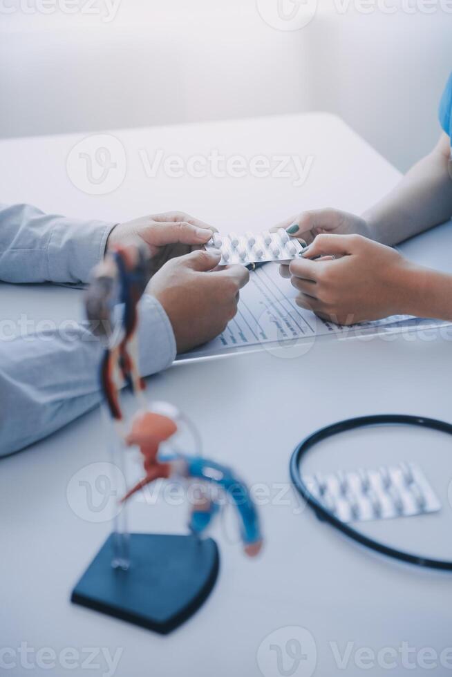 Doctor uses anatomical model to explain male urinary system. Model labeled with parts, doctor points and explains how they work together for urinary function, ensuring patient comprehension. photo