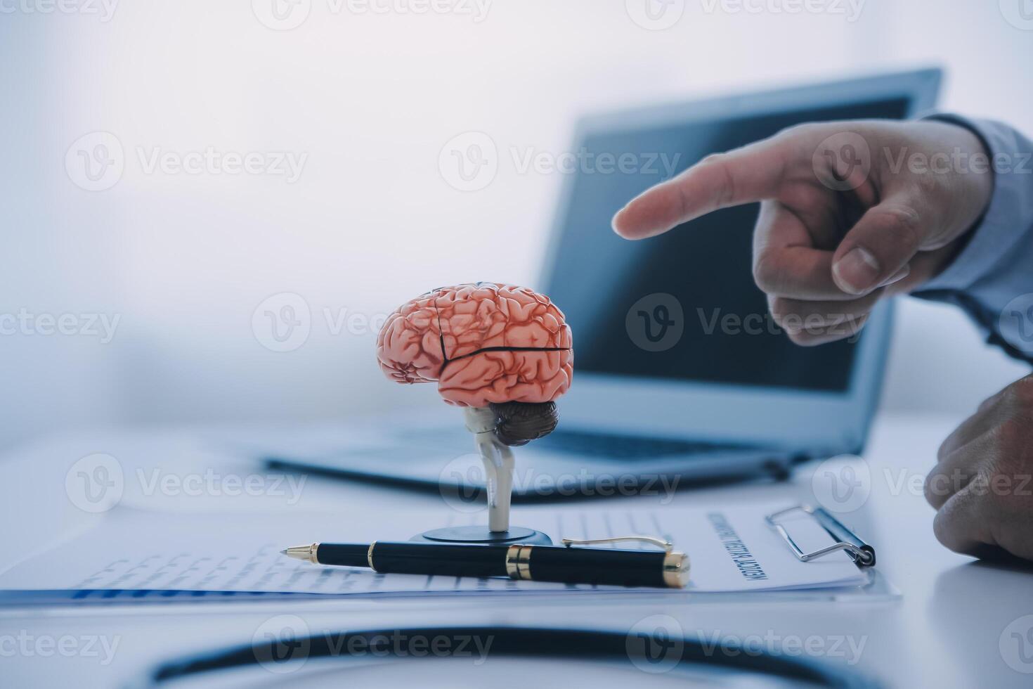 Doctor explaining brain functions to patient on model in office. photo