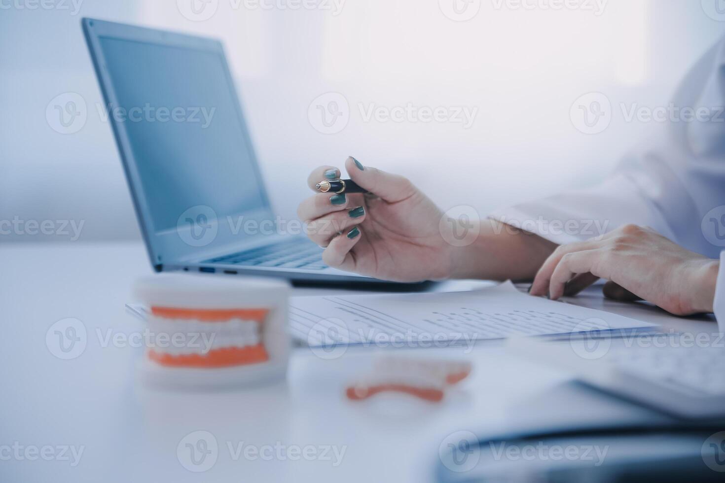 Dentists are discussing dental problems at report x-ray image on laptop screen to patients. photo
