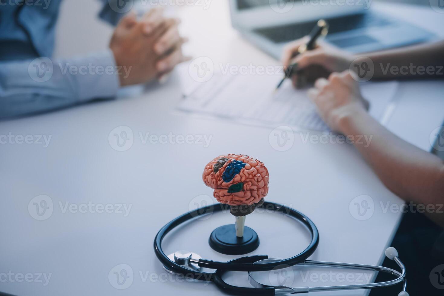 Doctor explaining brain functions to patient on model in office. photo
