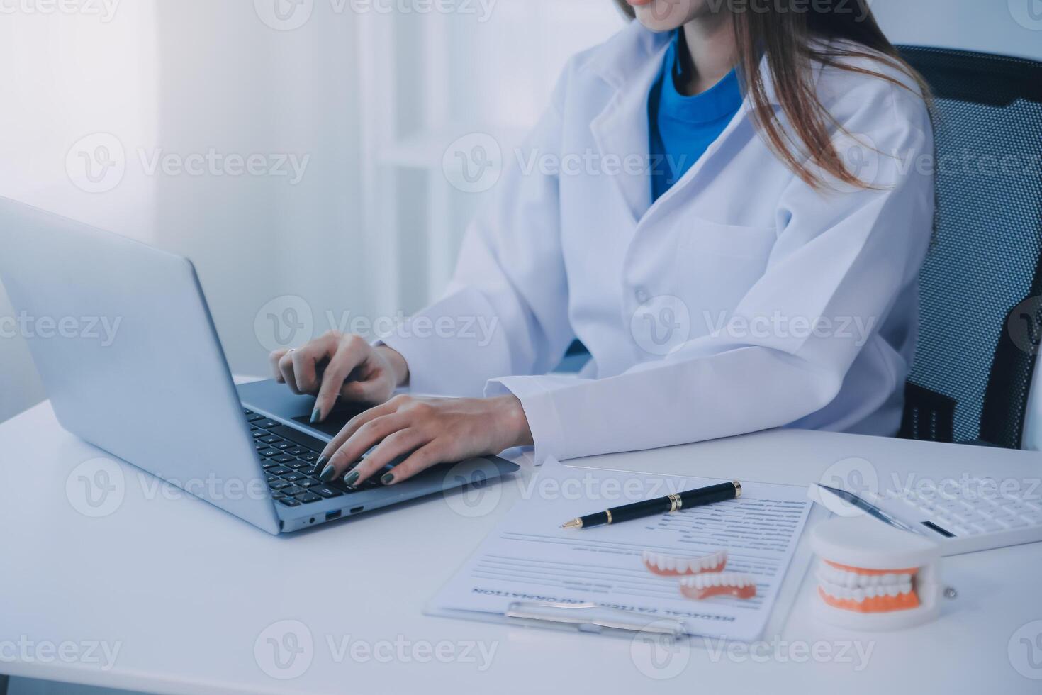 Dentists are discussing dental problems at report x-ray image on laptop screen to patients. photo
