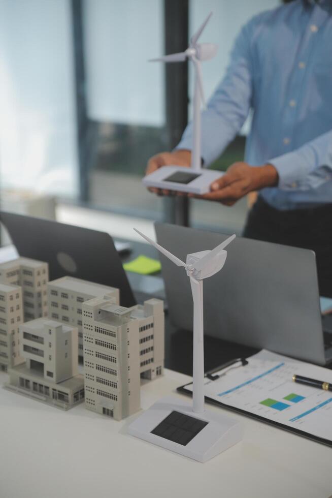 Close-up at tablet, Engineers pointing at tablet with their hands. To jointly design the use of renewable energy with wind and solar energy. Concept of using renewable energy. photo