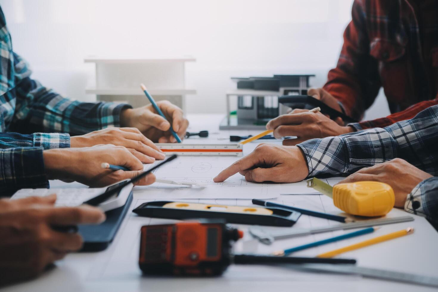 engineer people meeting working and pointing at a drawings in office for discussing. Engineering tools and construction concept. photo
