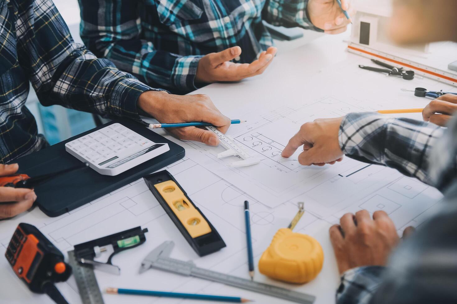 engineer people meeting working and pointing at a drawings in office for discussing. Engineering tools and construction concept. photo