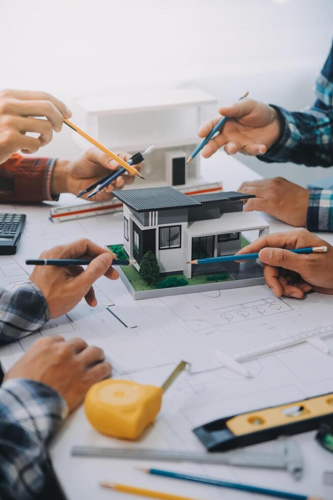 engineer people meeting working and pointing at a drawings in office for discussing. Engineering tools and construction concept. photo