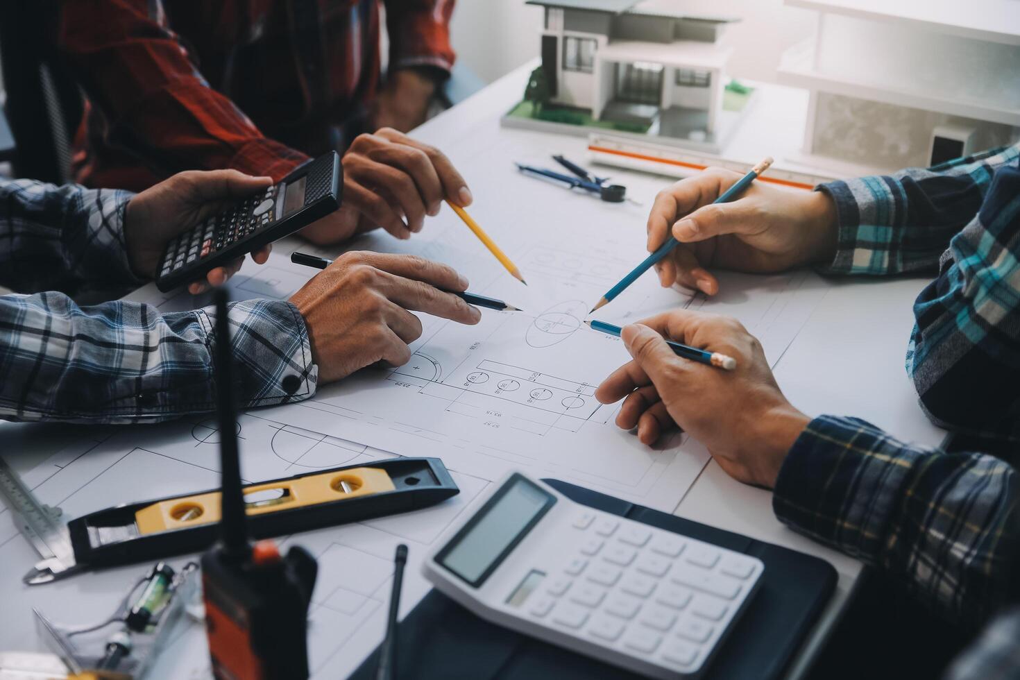 engineer people meeting working and pointing at a drawings in office for discussing. Engineering tools and construction concept. photo