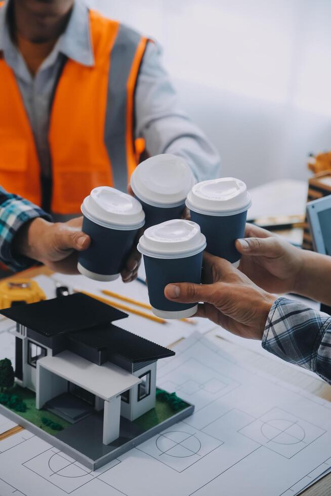 imagen de ingeniero reunión para arquitectónico proyecto. trabajando con compañero y Ingenieria herramientas en lugar de trabajo Clásico tono. foto