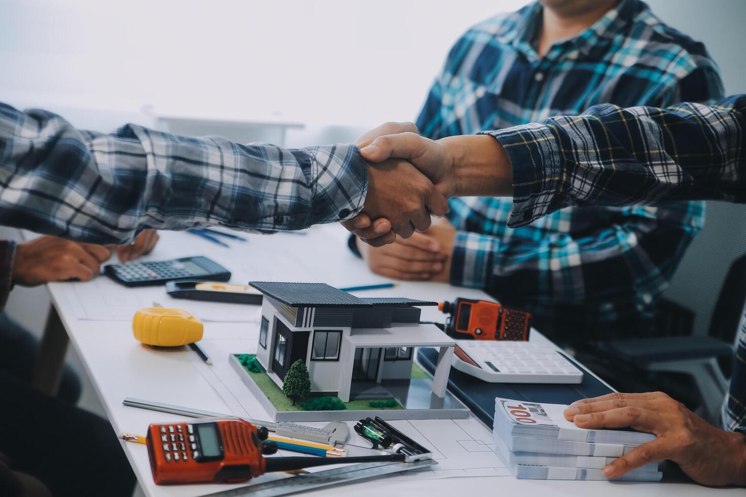 Architect and engineer construction workers shaking hands while working for teamwork and cooperation concept after finish an agreement in the office construction site, success collaboration concept photo