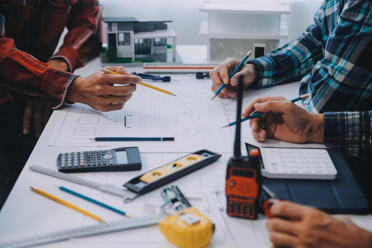 engineer people meeting working and pointing at a drawings in office for discussing. Engineering tools and construction concept. photo