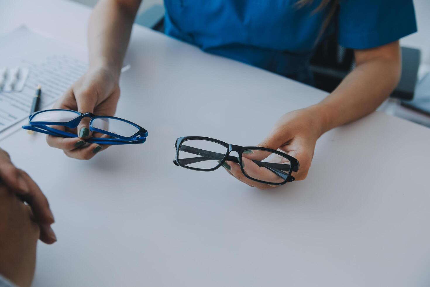 Close-up of Asian female doctor talking with elderly patient showing eyeball model and explaining eye disease in hospital photo