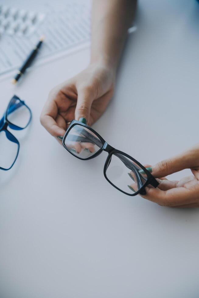 Close-up of Asian female doctor talking with elderly patient showing eyeball model and explaining eye disease in hospital photo
