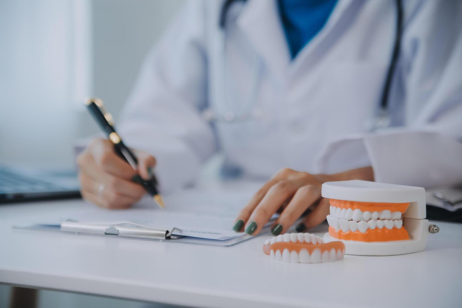 los dentistas están discutiendo problemas dentales al informar la imagen de rayos X en la pantalla del portátil a los pacientes. foto