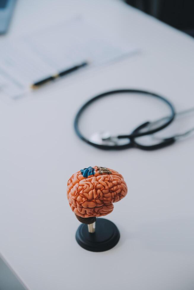 Doctor explaining brain functions to patient on model in office. photo