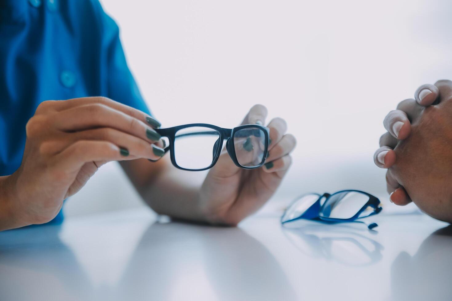 Close-up of Asian female doctor talking with elderly patient showing eyeball model and explaining eye disease in hospital photo
