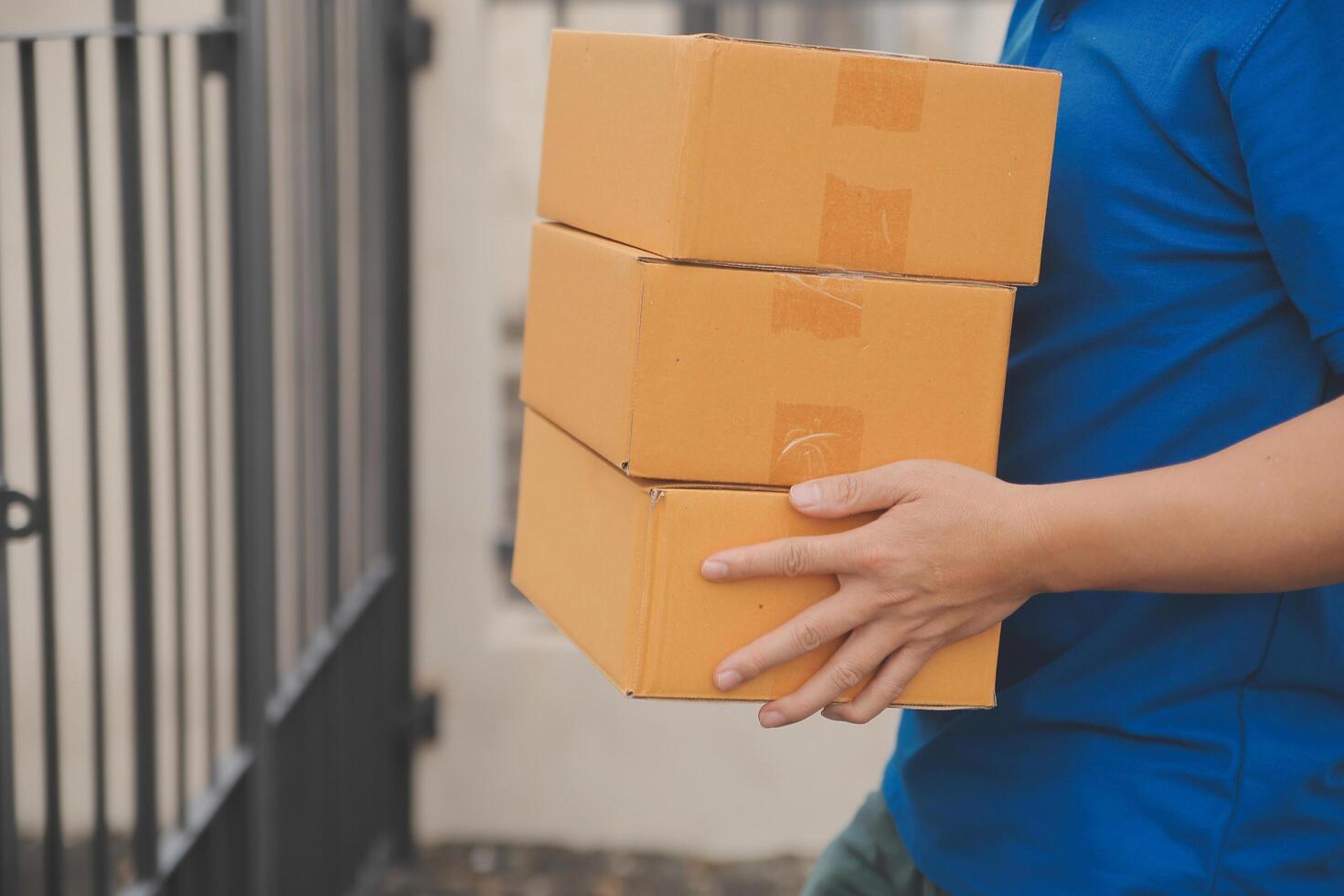 asiático entrega Rápido mensajero joven hombre utilizar dando cajas a mujer cliente él vistiendo protector cara máscara a frente hogar foto