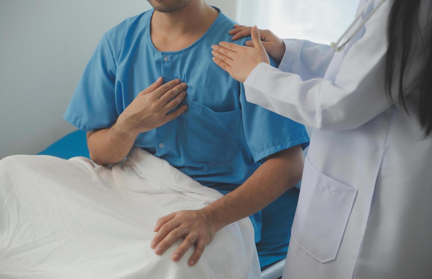 joven médico es utilizando un estetoscopio escucha a el latido del corazón de el paciente. Disparo de un hembra médico dando un masculino paciente un cheque arriba foto