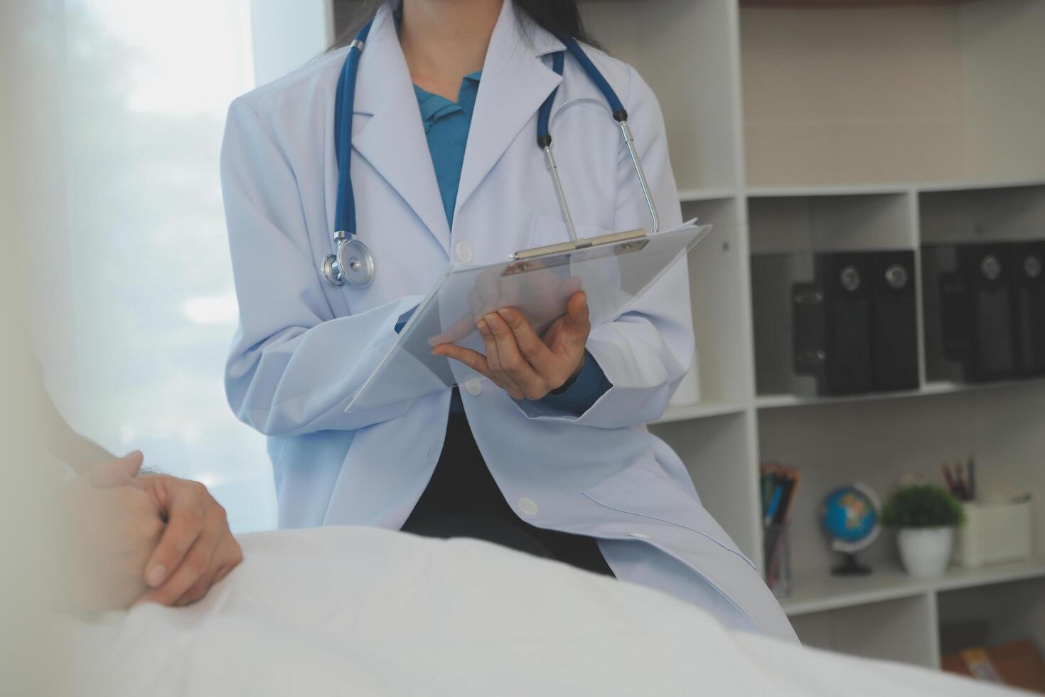 joven médico es utilizando un estetoscopio escucha a el latido del corazón de el paciente. Disparo de un hembra médico dando un masculino paciente un cheque arriba foto