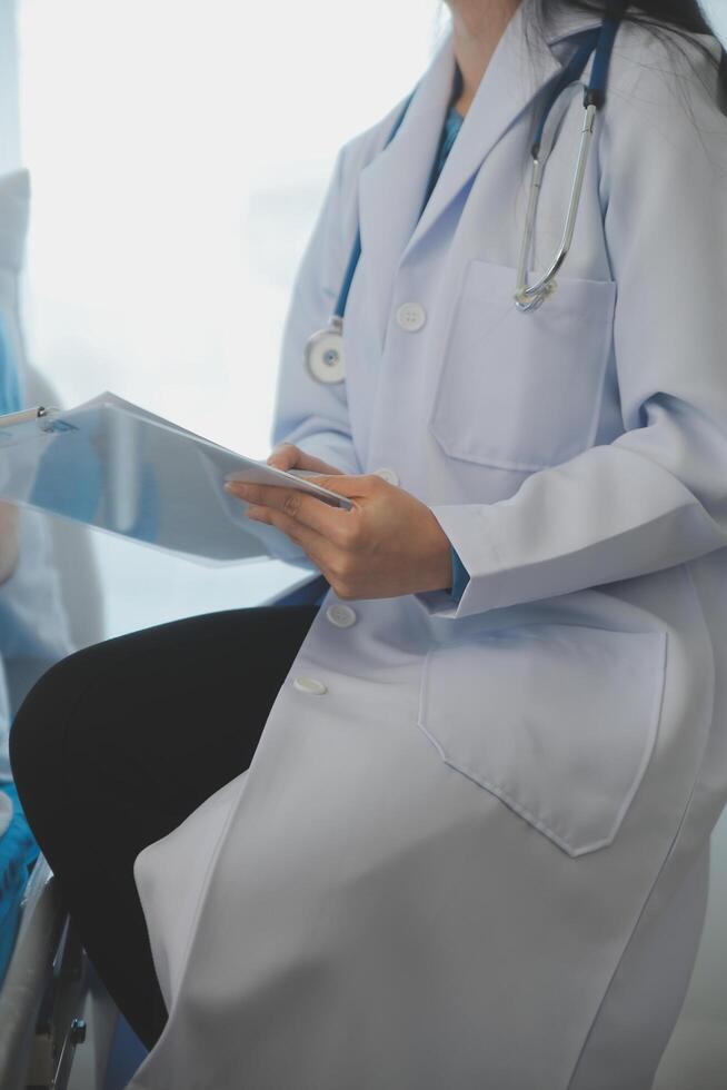 joven médico es utilizando un estetoscopio escucha a el latido del corazón de el paciente. Disparo de un hembra médico dando un masculino paciente un cheque arriba foto