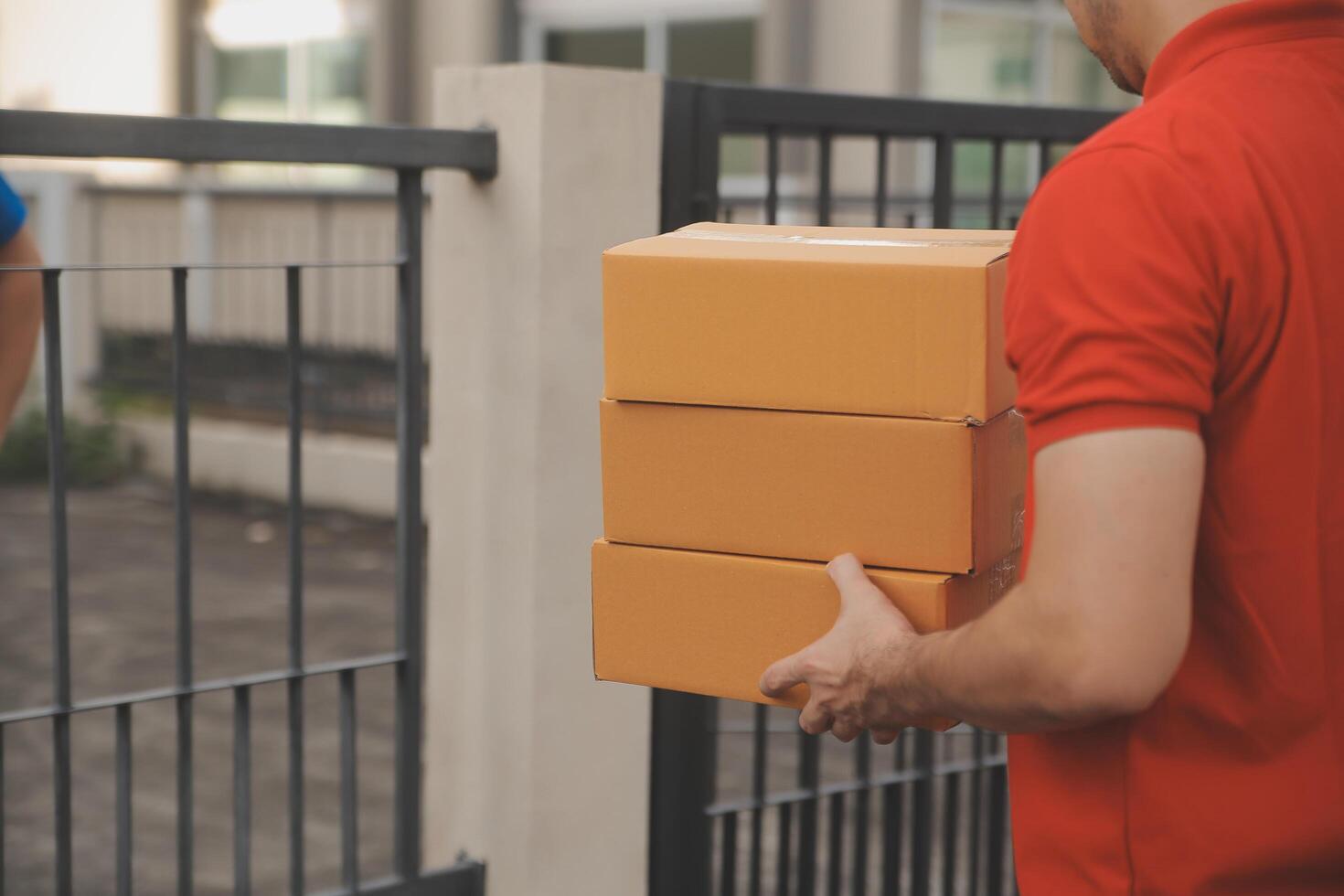 Asian delivery express courier young man use giving boxes to woman customer he wearing protective face mask at front home photo