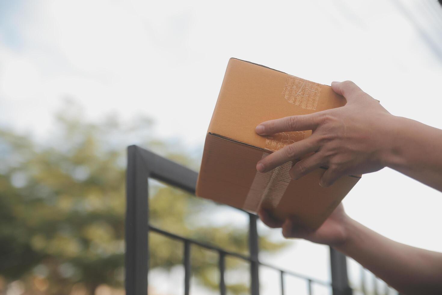 Asian delivery express courier young man use giving boxes to woman customer he wearing protective face mask at front home photo