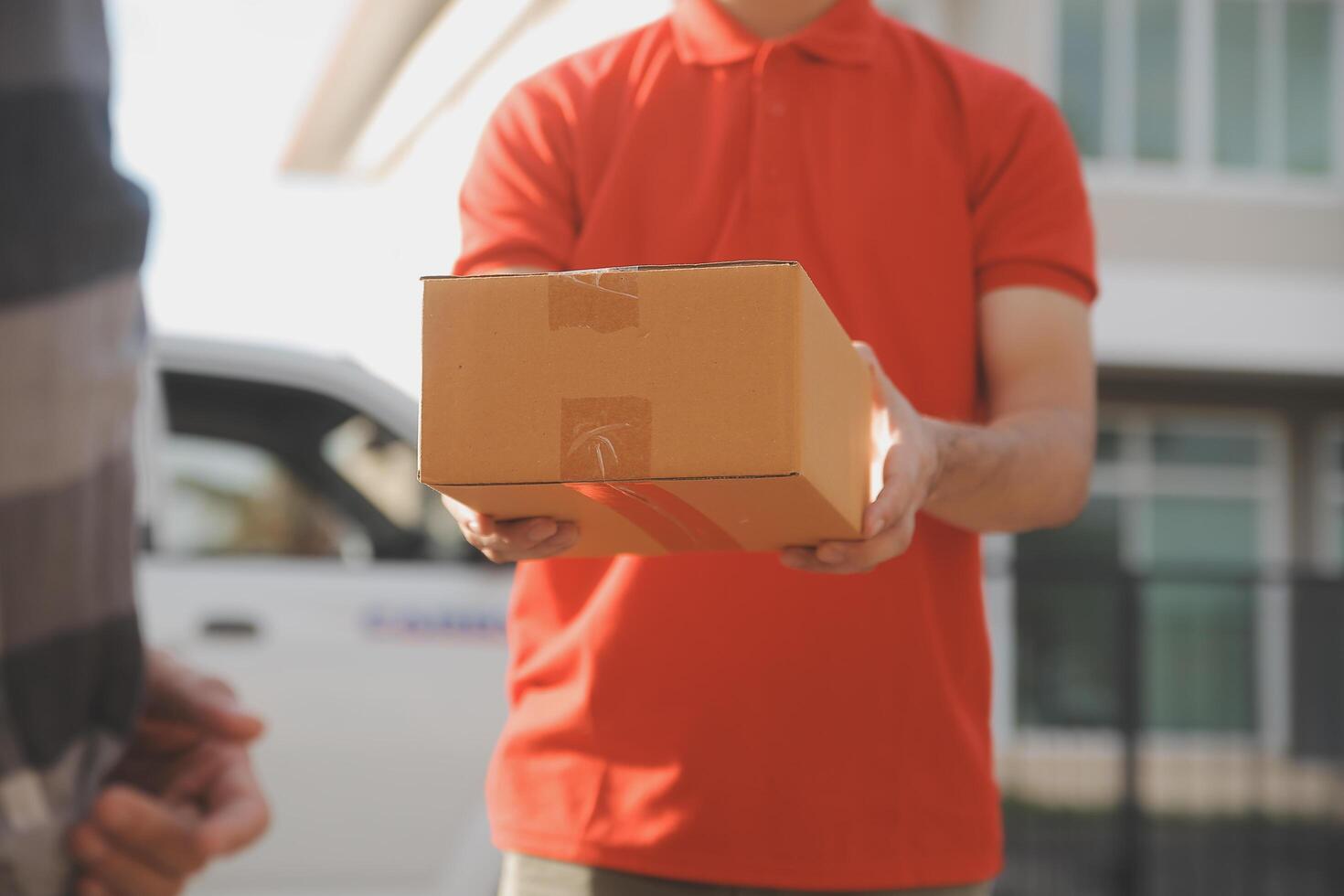 Asian delivery express courier young man use giving boxes to woman customer he wearing protective face mask at front home photo