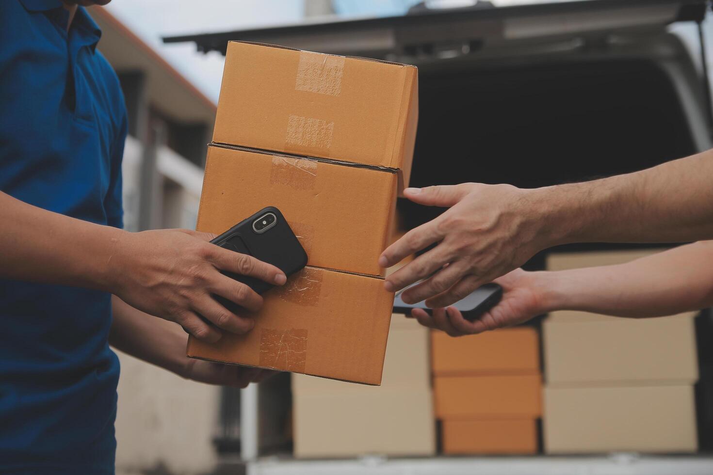 Asian delivery express courier young man use giving boxes to woman customer he wearing protective face mask at front home photo