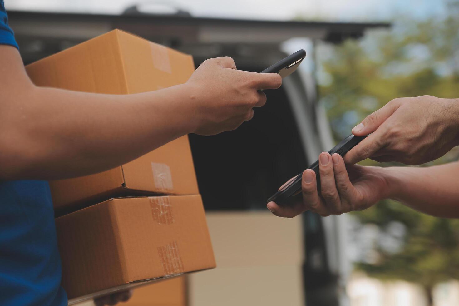 Asian delivery express courier young man use giving boxes to woman customer he wearing protective face mask at front home photo