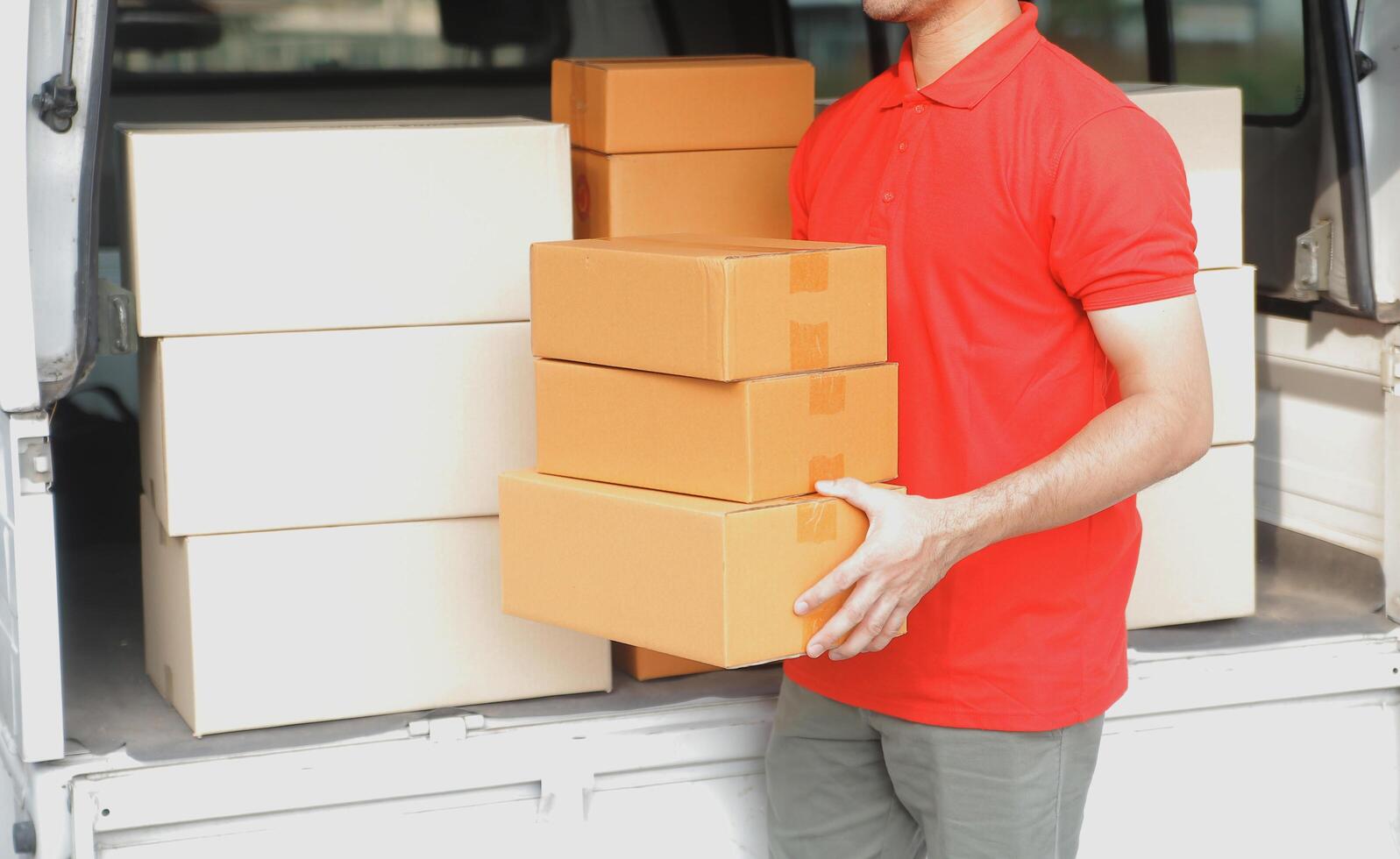 asiático entrega Rápido mensajero joven hombre utilizar dando cajas a mujer cliente él vistiendo protector cara máscara a frente hogar foto