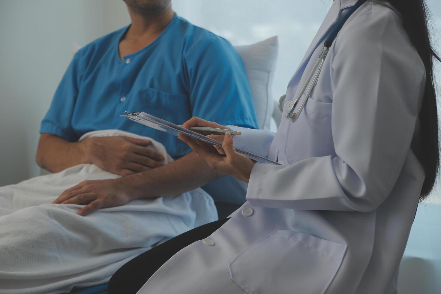 joven médico es utilizando un estetoscopio escucha a el latido del corazón de el paciente. Disparo de un hembra médico dando un masculino paciente un cheque arriba foto