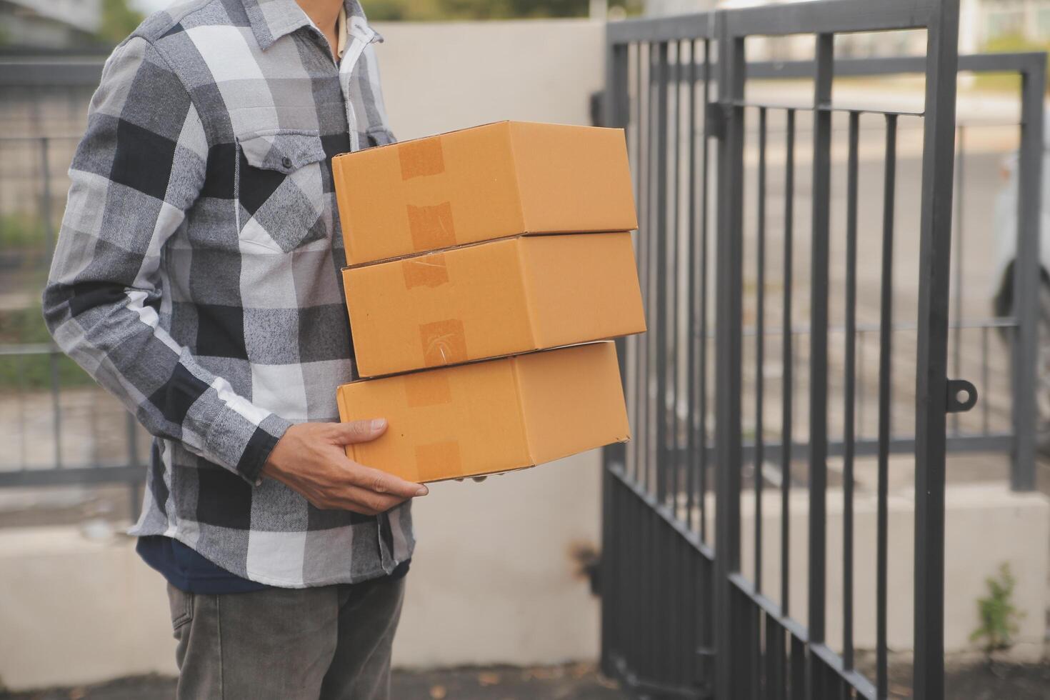 Asian delivery express courier young man use giving boxes to woman customer he wearing protective face mask at front home photo