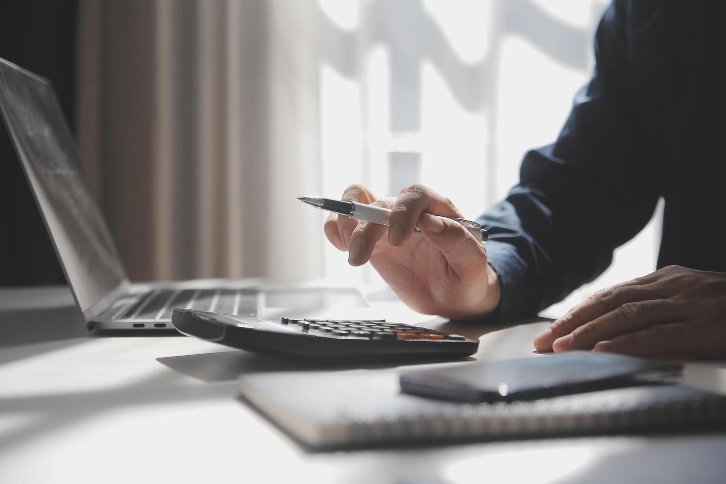 businessman working on desk office with using a calculator to calculate the numbers, finance accounting concept photo