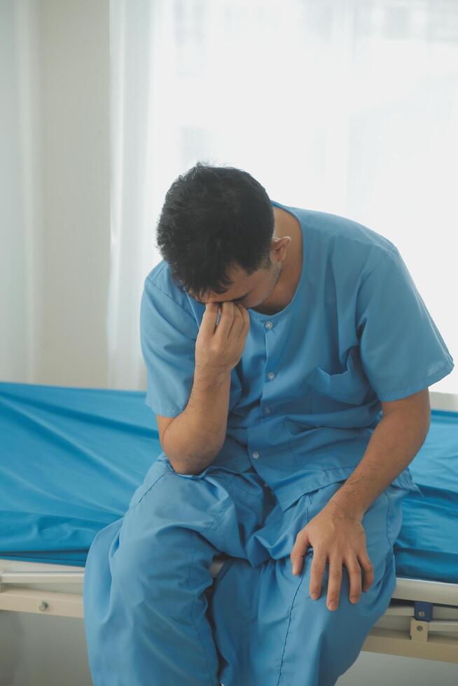 A male patient suffering from stress, migraines, eye strain, headaches, eye problems from working hard and not getting enough rest receives treatment from a doctor at the hospital. photo