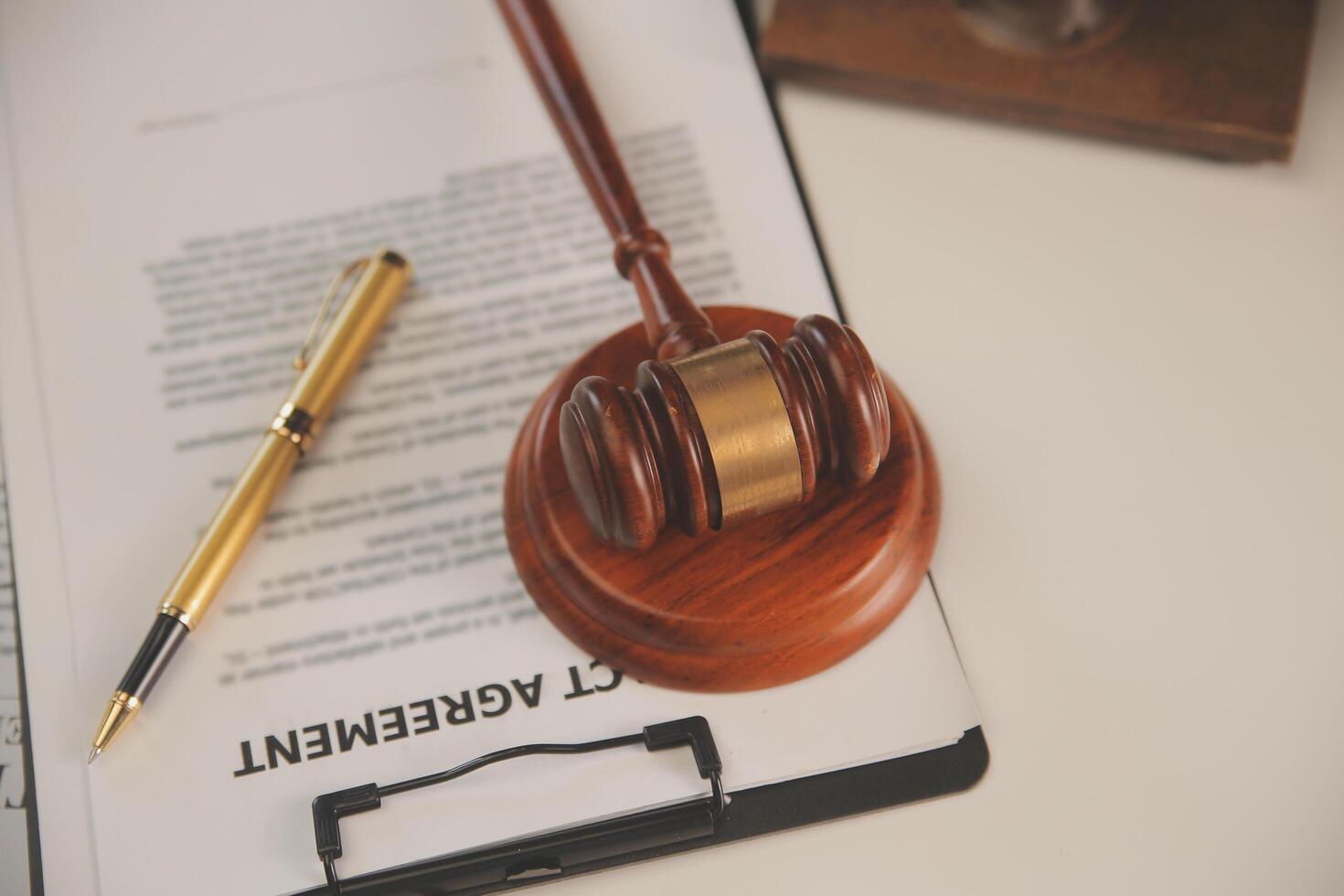 image of judge's hammer, scales lady of justice, law book, laptop computer and contract documents with pen concept of law and justice. photo