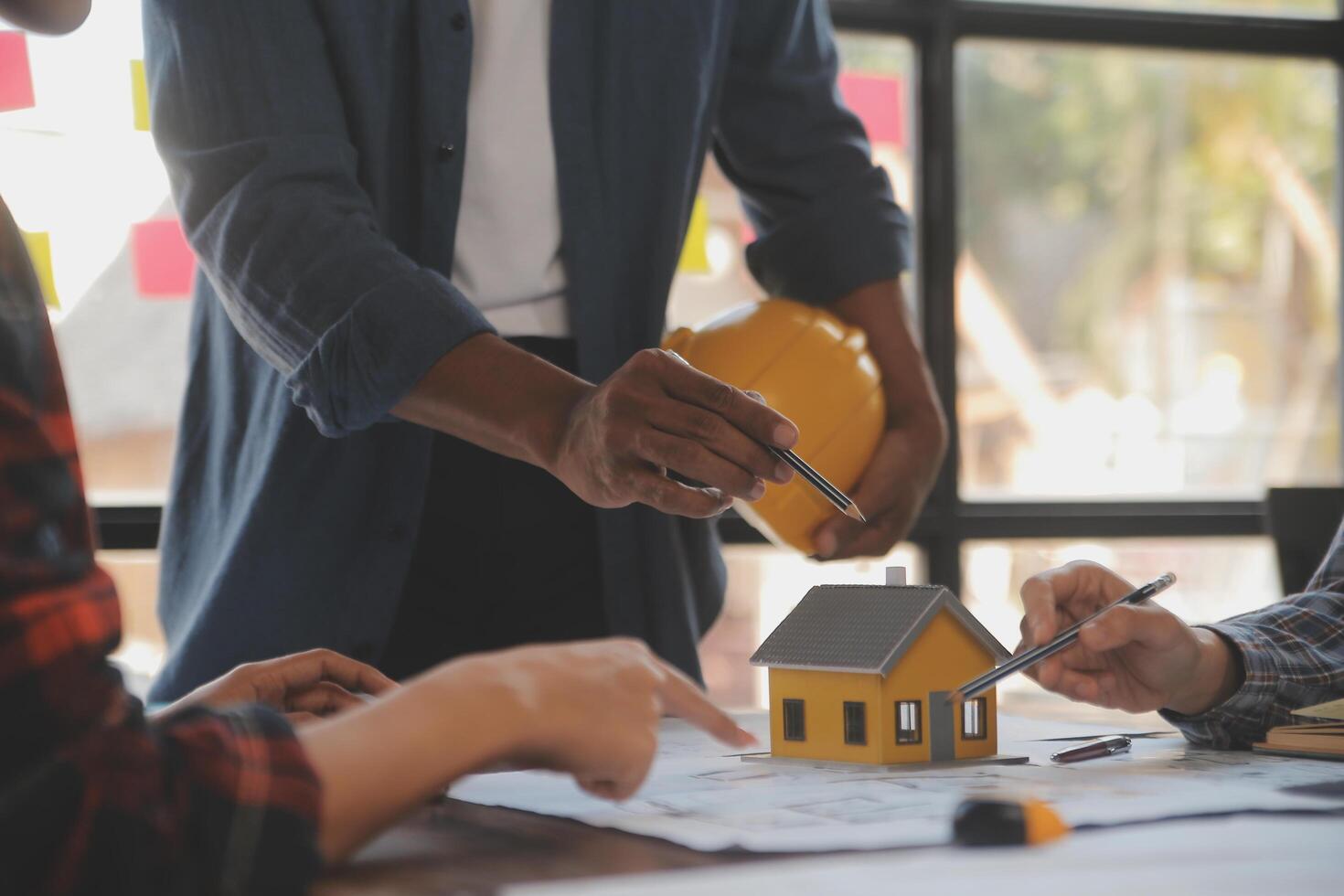 un equipo de construcción ingenieros negociaciones a gerentes y construcción trabajadores a el construcción sitio. calidad inspección, trabajo plan, hogar y industrial edificio diseño proyecto foto