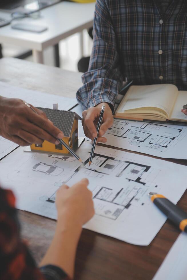 A team of construction engineers talks to managers and construction workers at the construction site. Quality inspection, work plan, home and industrial building design project photo