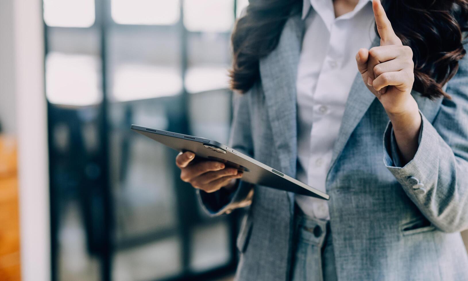 Asian Business woman using calculator and laptop for doing math finance on an office desk, tax, report, accounting, statistics, and analytical research concept photo