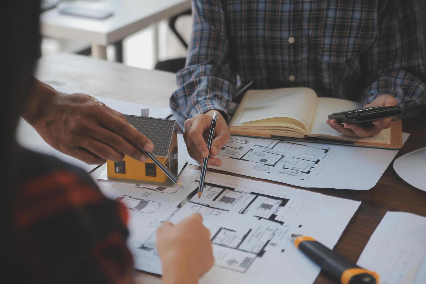 un equipo de construcción ingenieros negociaciones a gerentes y construcción trabajadores a el construcción sitio. calidad inspección, trabajo plan, hogar y industrial edificio diseño proyecto foto