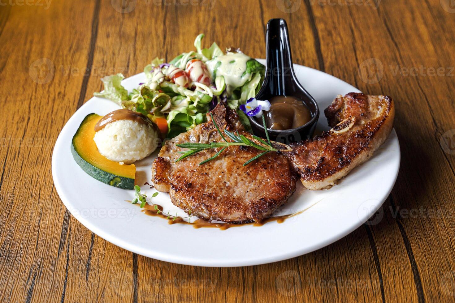 Pork Chop Steak is a pork steak that uses thigh meat or bone-in sirloin. Pork chops are soft, juicy, and have a little bit of fat. Eat with salad, mashed potatoes, and sauce. photo