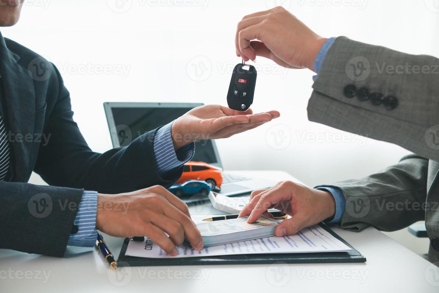 car dealer is handing over car keys to customer after sales contract and installment contract have been signed. Concept of handing over car keys to customers after the sales contract has been approved photo