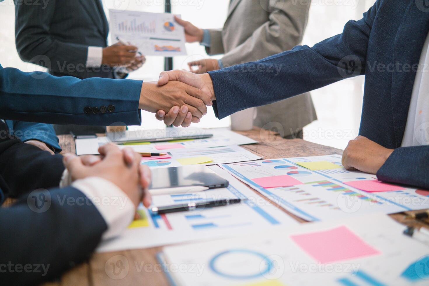 committee of businessmen and investors join hands as symbol of joint investment after discussing consulting and making contract  invest in business together. committee joins hands in meeting. photo