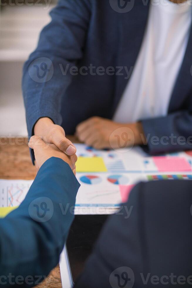 Businessmen and investors shake hands as symbol of joint venture after discussing, consulting and making contract to invest in business together. business people shaking hands as symbol of cooperation photo