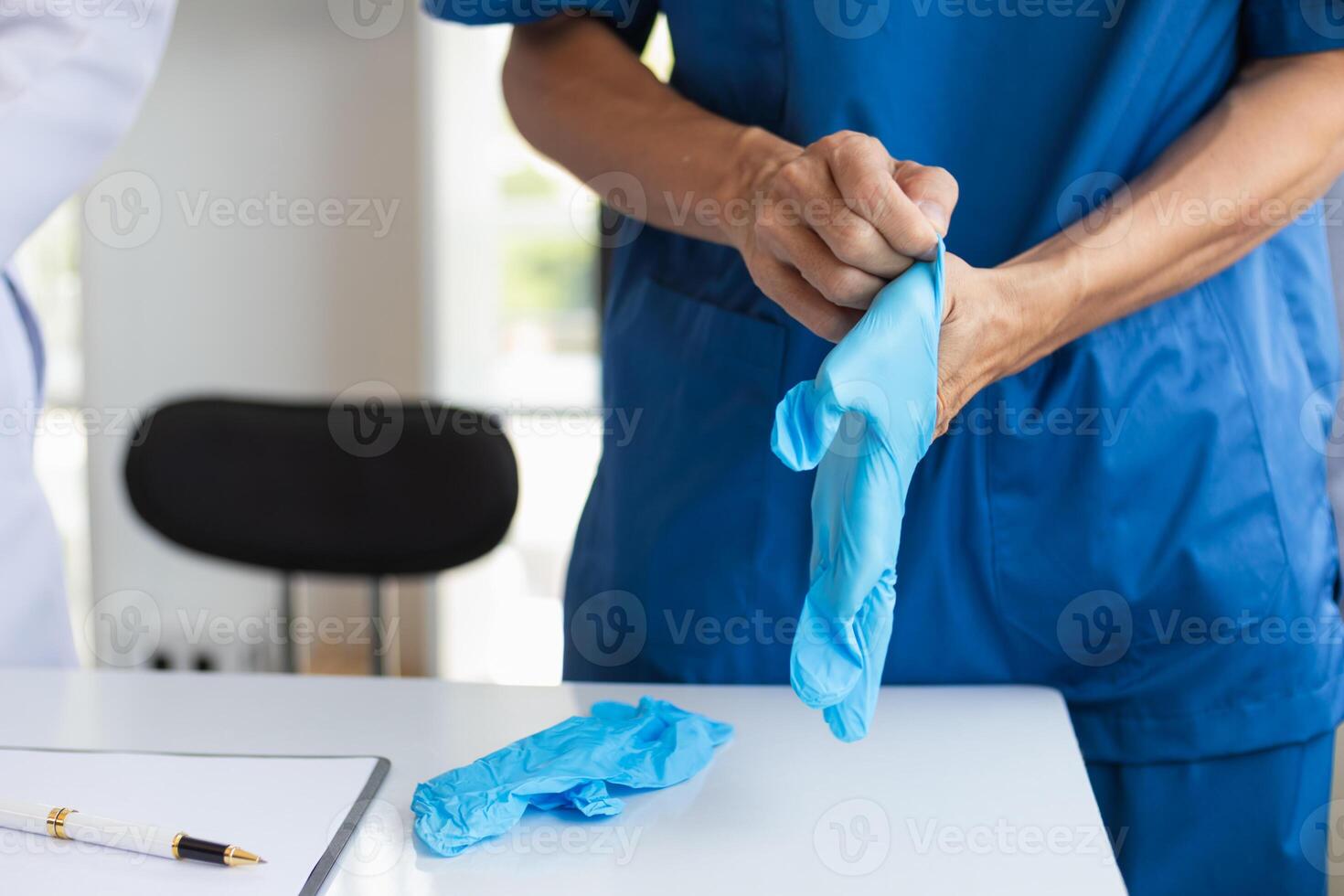 doctor is wearing blue rubber gloves prevent direct contact with patient because virus may be traced to patient body and medical rubber gloves also help prevent virus from being transmitted to patient photo