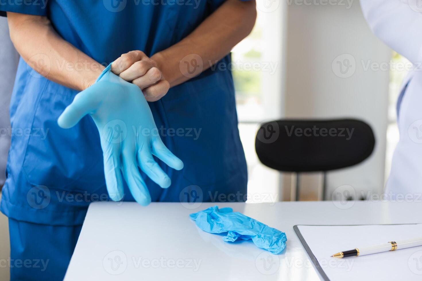 doctor is wearing blue rubber gloves prevent direct contact with patient because virus may be traced to patient body and medical rubber gloves also help prevent virus from being transmitted to patient photo