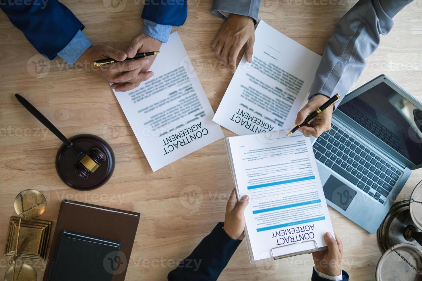 Businessmen and investors discussed joint venture within the legal counsel office and agreed to sign a contract in front of the lawyers within the legal counsel office to witness the joint investment. photo