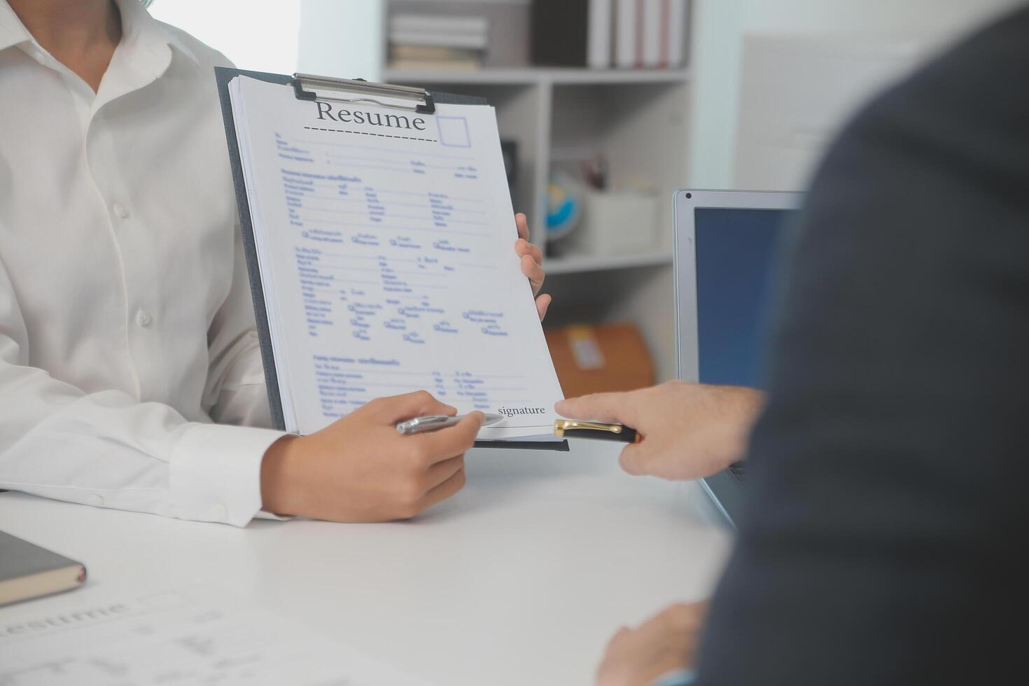 Close up view of job interview in office, focus on resume writing tips, employer reviewing good cv of prepared skilled applicant, recruiter considering application, hr manager making hiring decision photo