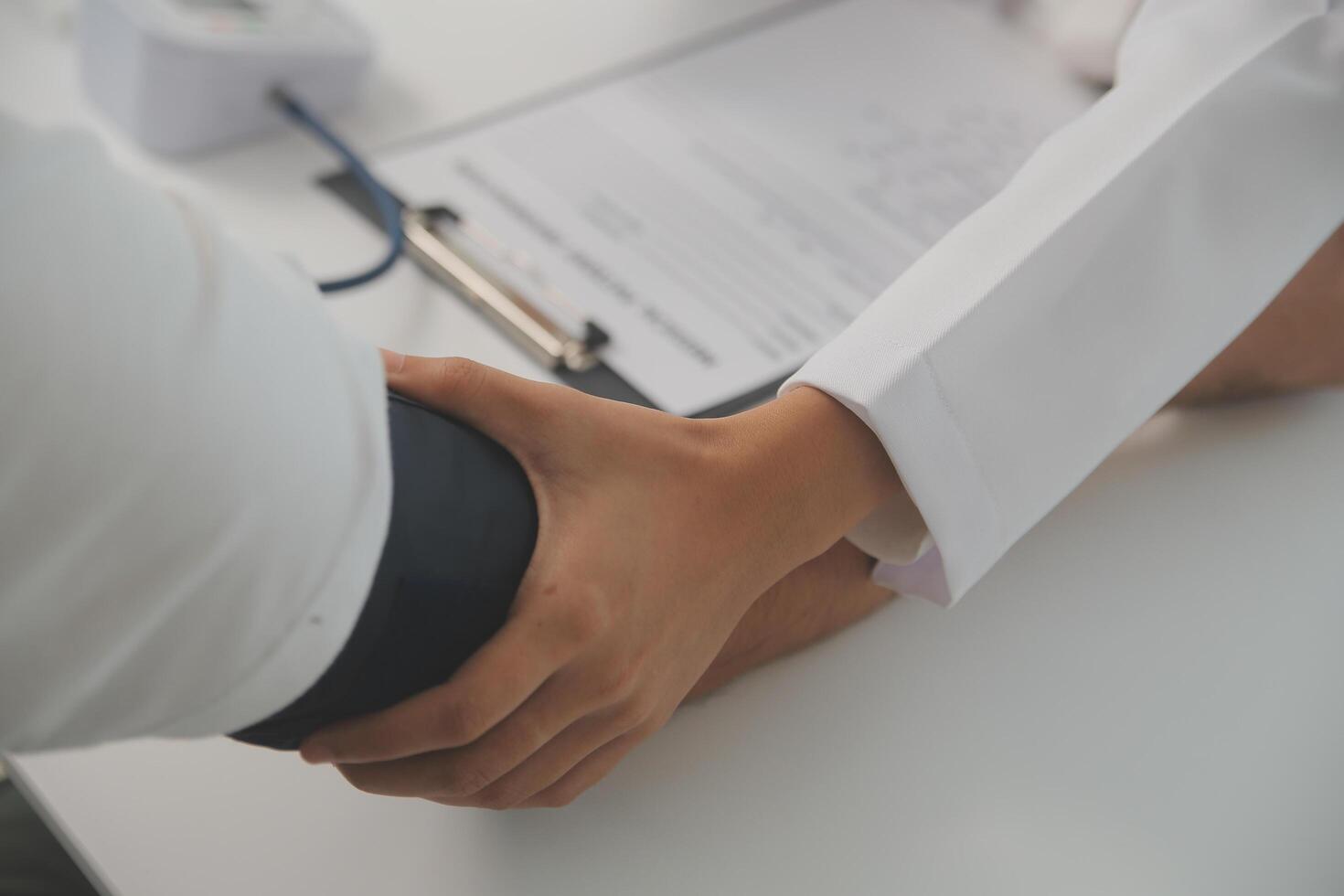 Male doctor uses a blood pressure monitor to check the body pressure and pulse of the patients who come to the hospital for check-ups, Medical treatment and health care concept. photo