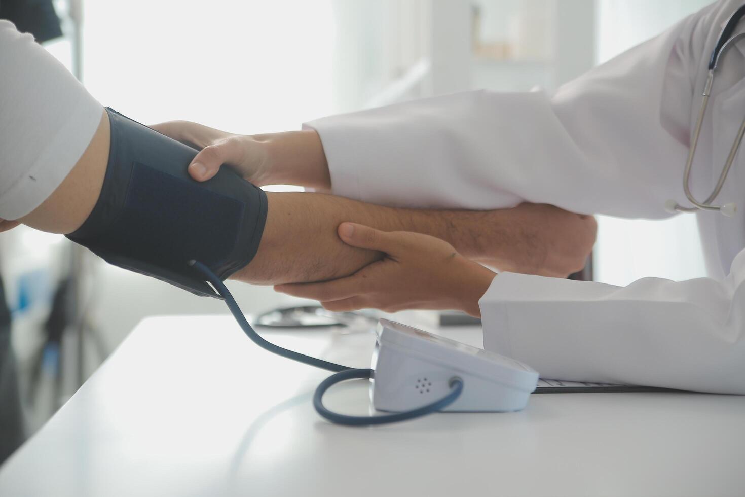 Male doctor uses a blood pressure monitor to check the body pressure and pulse of the patients who come to the hospital for check-ups, Medical treatment and health care concept. photo