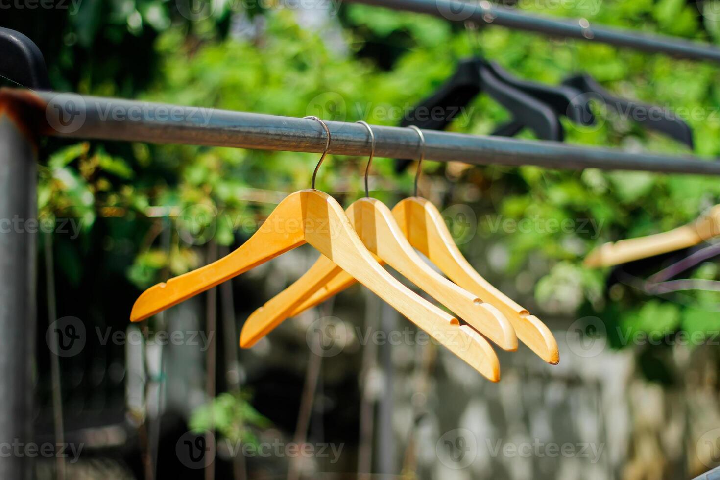 wooden clothes hanger with a natural leafy background in the garden photo